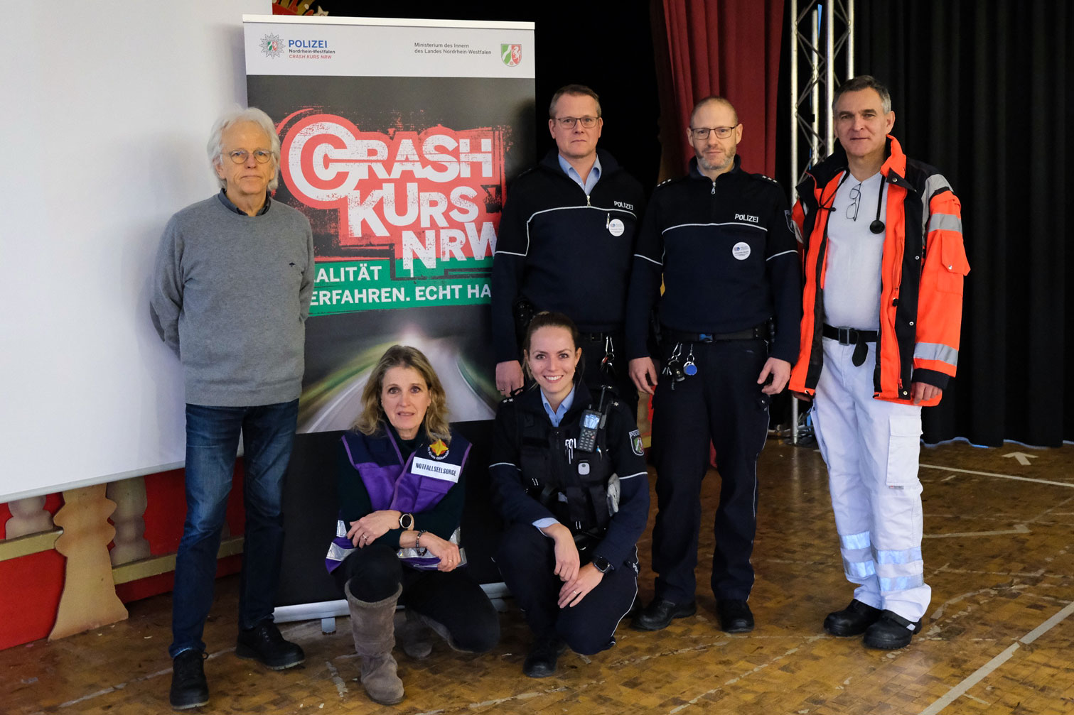 Das Team Crash Kurs vor einem Banner der Veranstaltung