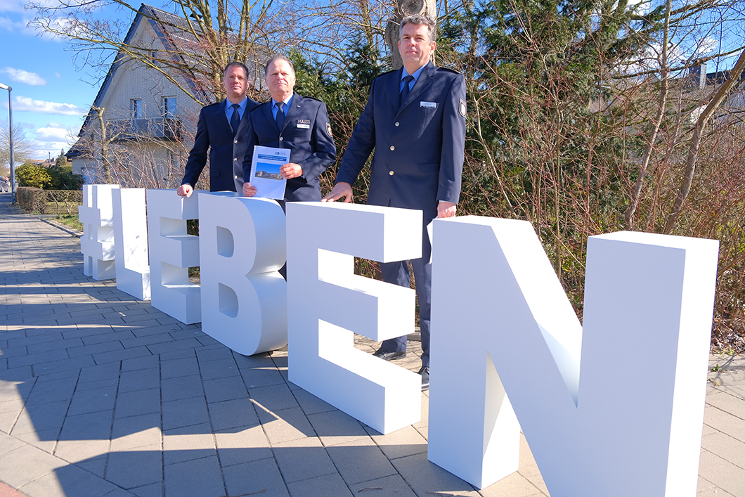 Polizeihauptkommissar Heiko Patzelt, Polizeioberrat Volker Pfeiffer, Leitender Polizeidirektor Holger Meier stehen hinter großen weißen Buchstaben #LEBEN