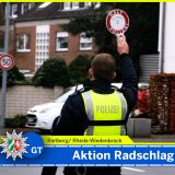 Polizist von hinten mit einer Polizeikelle. Headline: Aktion Radschlag - Verkehrskontrollen. Ortsangabe: Rietberg/ Rheda-Wiedenbrück