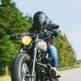 Motorradfahrer während der Fahrt. Text: Brief zum Start der Motorradsaison