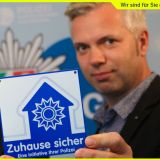 Technische Sicherheitsberater - Uwe Arlitt und Guido Baratella halten die "Zuhause sicher" Plakette in die Kamera