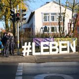 Große weiße Buchstaben #LEBEN stehen am Straßenrand des Ostrings. Daneben findet eine Geschwindigkeitskontrolle der Polizei Gütersloh statt