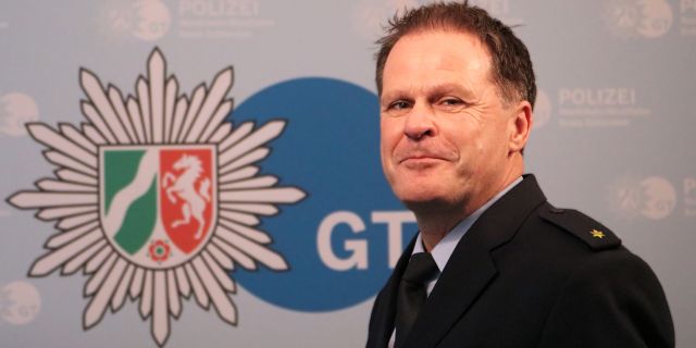 Volker Pfeiffer im Hintergrund das Logo der Polizei Gütersloh