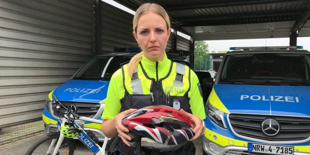 Polizeikommissarin Katharina Philippi hält einen beschädigten Fahrradhelm in den Händen
