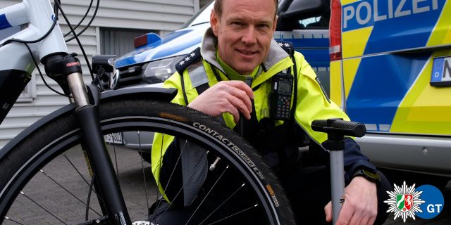 Polizeihauptkommissar Markus Meyer zu Erpen kniet neben seinem Fahrrad