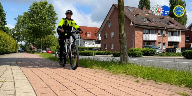 Ein Polizist fährt mit einem Fahrrad auf einem Fahrradweg