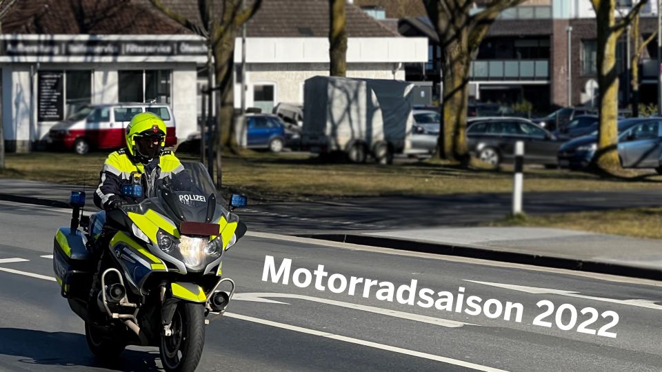 Ein Polizeibeamter auf einem Polizeimotorrad, während der Fahrt fotografiert