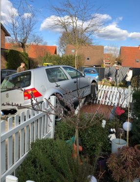 Ein silberner VW Golf hat einen weißen Gartenzaun umgefahren