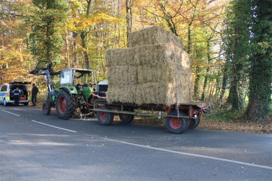 Ein Ackerschlepper mit einem Anhänger, voll beladen mit Strohballen