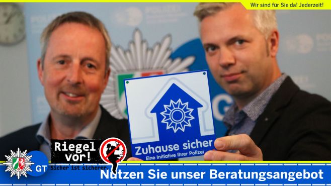 Technische Sicherheitsberater - Uwe Arlitt und Guido Baratella halten die "Zuhause sicher" Plakette in die Kamera