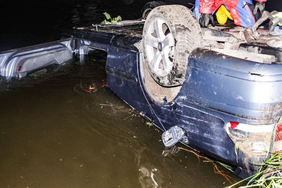 Blauer Unfallwagen liegt auf dem Kopf im Wasser